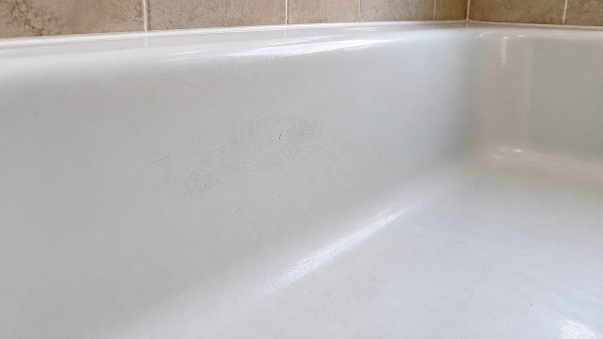 Dull surface marks along the inside of a white bathtub