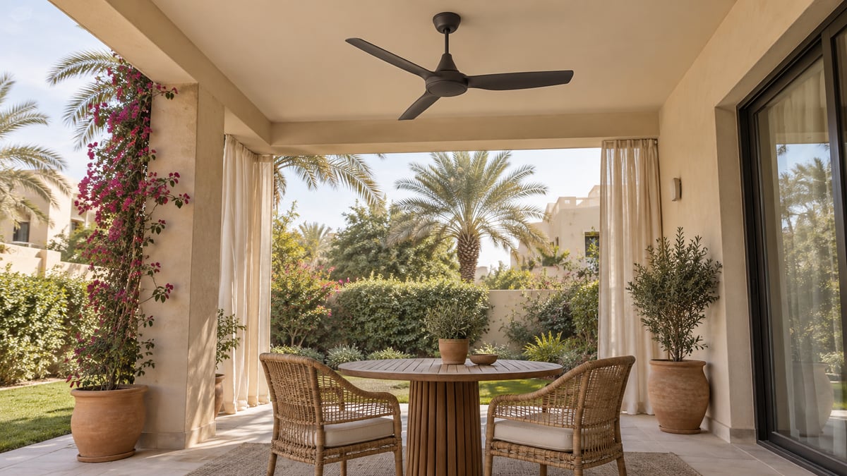 Ceiling fan beneath a solid covered terrace roof beside an open garden