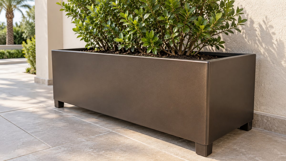 Rectangular metal planter with folded edges and short feet on a villa patio