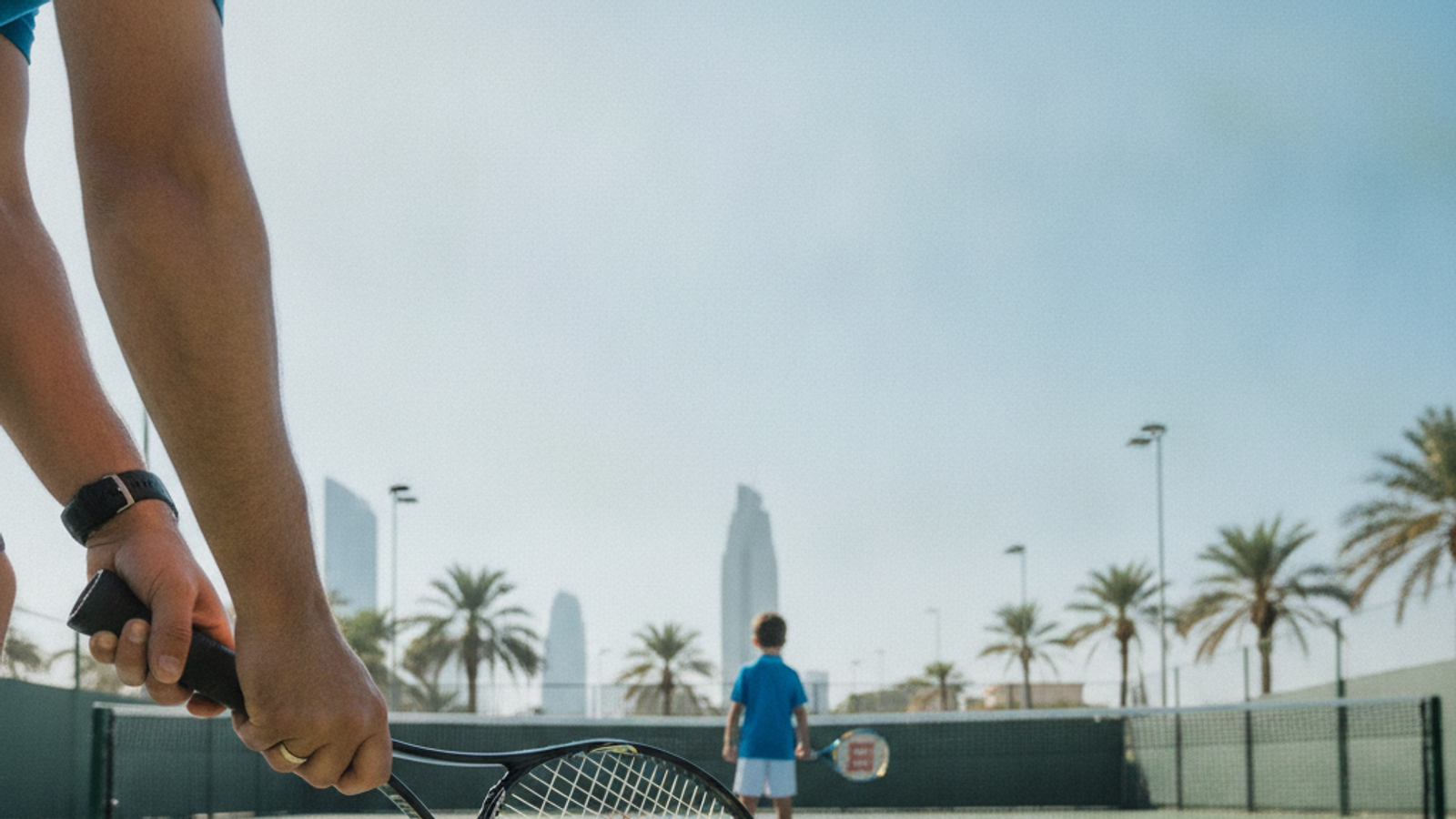 tennis coach preparing racket and balls for a kids lesson in Dubai